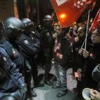 Protesters shout slogans in front of an open shop as police stand guard during a general strike in Madrid, Spain, Wednesday, Nov. 14, 2012. Spain's main trade unions stage a general strike, coinciding with similar work stoppages in Portugal and ...