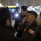 Protestors shout slogans to stop the buses to run as the police stand guard outside a main bus garage during a general strike in Madrid, Spain, Wednesday, Nov. 14, 2012. Spain's main trade unions stage a general strike, coinciding with similar w...