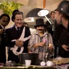 Anti-austerity protesters, including one with a mask bearing an image of Britain's Prime Minister David Cameron, second left, take part in what they called 'the Plebs & PIIGS Banquet', a demonstration outside the Lord Mayor's Banquet in the City...