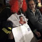 Justo Huerta Tomás, de Guadalajara, vestido de payaso y con una fotografía de su madre, ha asistido al Teatro Real de Madrid para presenciar el Sorteo Extraordinario de Navidad, con una pancarta con los números de los décimos que ha comprado...
