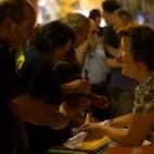 Una vecina recoge platos de comida mientras charla.