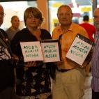 Varios vecinos sostienen las huchas con las que recaudan fondos para los mineros.