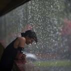 Una mujer disfruta la intensa lluvia en Tampa, Florida.
