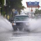 Un vehículo transita por una vía inundada en Key West, Florida (EE.UU.) este domingo.