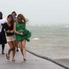 Un grupo de personas corren junto a la orilla del mar a lo largo de un muelle en Key West.