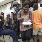 Varios vecinos de Puerto Príncipe reciben ayuda de la Organización Internacional para las Migraciones (OIM) en un campamento para personas desplazadas.