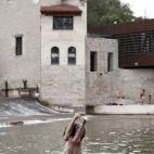 Un joven se lanza al agua en el rio Arga a su paso por Pamplona