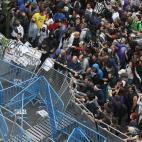 Los manifestantes empujan las vallas