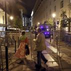 Dos personas acceden a los alrededores del Congreso de los Diputados, vallado por la Policía.