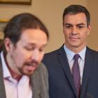 Pedro Sánchez observa a Pablo Iglesias mientras este firma el preacuerdo de Gobierno