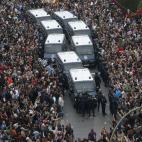 Los manifestantes rodean a las furgonetas de la policía