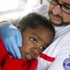 Un miembro de la Cruz Roja atiende a un niño rescatado de las costas españolas (11 de agosto).