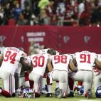 Los jugadores de los New York Giants rezan por las víctimas de Newtown antes de su partido ante los Atlanta Falcons.