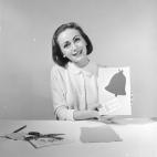 Una mujer sostiene una felicitación navideña hecha a mano, con la que felicitará el año 1956.