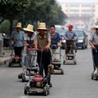 24 septiembre 2012 Los habitantes del pueblo chino de Nanjie, en la provincia de Henana, marchan juntos equipados con segadoras. El pueblo, de 3.100 habitantes, es considerado uno de los lugares donde el primigenio modelo comunista chino ha cam...