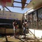 Dos mujeres, con sus hijos en brazos, en lo que queda de una escuela tras el paso del tifón más fuerte que ha asolado el archipiélago en 2012. 4 días de lluvia y viento que han dejado más de 1.000 muertos y desaparecidos.