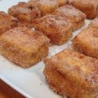 Se prepara con lecha, azúcar, maizena, piel de naranja, canela. en rema, huevo, canela y azúcar para rebozar. Consulta aquí la receta completa.