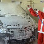 Un trabajador indio vestido de Papá Niel lava un coche en Amritsar, India.