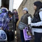 Elia Olmedo, segunda empezando por la derecha, habla con su amiga Lucina Muñoz, a la izquierda, mientras sus hijas, Jaquelin Prado, de doce años, y Karin López, de seis, escuchan, frente a la casa de Olmedo en Staten Island, Nueva York. Image...