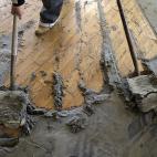 ARCHIVO- La foto de archivo del 02 de noviembre de 2012 muestra a un trabajador recogiendo arena en una residencia en Longport, Nueva Jersey, tras el paso del huracán Sandy. Jornaleros inmigrantes lanzaron una campaña para distribuir materiale...