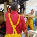 Tras haber soltado la red al mar, ahora los pescadores comienzan a recogerla.