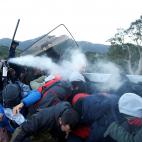 Un agente trata de dispersar a los manifestantes que cortan una carretera en Cataluña