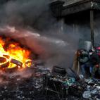 Enero de 2014. Manifestantes pro europeos se cubren durante los enfrentamientos con la Polic&iacute;a en Kiev (Ucrania).