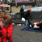 Febrero de 2014. Una mujer llora mientras dos hombres cargan un cad&aacute;ver durante las protestas en la Plaza de la Independencia de Kiev (Ucrania).
