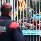 Un agente, ante una valla, vigila a los manifestantes