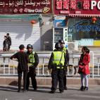 Policía interrogando a ciudadanos en Hotan