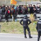 Spanish riot police faces Catalan separatists after breaking up a blockade set up on AP-7 motorway linking Spain to neighbouring France, near Figueras on March 27, 2018. Spanish riot police broke up a blockade by Catalan separatists on major mot...