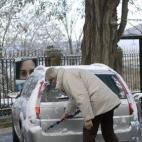 Un hombre quita la nieve de su coche en Segovia. Todas las provincias de Castilla y León, salvo Valladolid, están en aviso por nevadas o frío intenso que llegará hasta los 6 grados bajo cero en zonas de montaña.