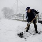 Un hombre retira la nieve con una pala en la entrada de su casa en la localidad orensana de Casetas de Rodicio (Maceda).