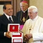 FILE - In this Friday, June 6, 2008 file photo, Italian Premier Silvio Berlusconi shows one of the gifts he received from Pope Benedict XVI, a pen commemorating St. Peter, on the occasion of their meeting at the Vatican City. Premier Silvio Berl...