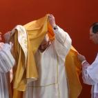 Pope Benedict XVI (C) wears his vest during a pastoral visit to the parish of 'Santa Maria del Rosario ai Martiri Portuensi' in the outskirts of Rome, 16 December 2007. AFP PHOTO / ALBERTO PIZZOLI (Photo credit should read ALBERTO PIZZOLI/AFP/Ge...