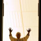 VATICAN, Vatican: Pope benedict XVI lights a peace candle at the window of his private apartment at the Vatican City, 24 December 2005, before celebrating midnight Mass. AFP PHOTO / Vincenzo PINTO (Photo credit should read VINCENZO PINTO/AFP...