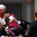 VATICAN CITY - DECEMBER 7: Pope Benedict XVI kisses a child as the faithful gather in St. Peter's Square as he arrives for his weekly audience on December 7, 2005 in Vatican City. According to news reports, details of the pontiff's first visit t...