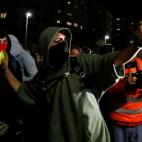 Un manifestante lanza un globo de pintura