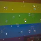 Pompas de jabón delante de la bandera multicolor, en la 5ª Avenida de Nueva York.