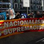 Un grupo de personas se concentra tras una bandera con la leyenda "El nacionalisme és supremacisme" ("El nacionalismo es supremacismo") ante el Supremo.