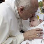 In this photo taken on Saturday Sept. 26, 2015 Pope Francis kisses a baby on his way to the Indipendence Mall in Philadelphia. (L'Osservatore Romano/Pool Photo via AP)