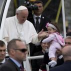 Pope Francis looks to a baby that he just kissed as he pauses in the popemobile during a parade along Benjamin Franklin Parkway in Philadelphia, Sunday, Sept. 27, 2015, on his way to celebrate mass. (AP Photo/Carolyn Kaster)