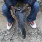 Samuel, de Nigeria, muestra su flotador casero sentado en su escondite en las montañas.