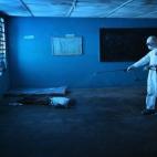 Un trabajador desinfecta un cadáver en una sala de aislamiento en Liberia