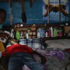 Un niño prepara a su padre, sospechoso de tener ébola, para su traslado a un centro de aislamiento.