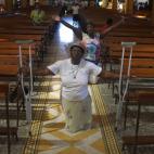 Una mujer, que apoya al presidente Chávez, se arrodilla y pide por la recuperación de éste.