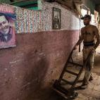 Un trabajador cubano ante una imagen de Chávez.