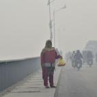 A woman sells rose petals on a bridge amid the heavy smog condition in Lahore on November 21, 2019. (Photo by Arif ALI / AFP) (Photo by ARIF ALI/AFP via Getty Images)