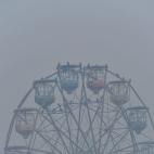 Birds sit on a ferris wheel amid heavy smog conditions in Lahore on November 21, 2019.   (Photo by Arif ALI / AFP) (Photo by ARIF ALI/AFP via Getty Images)