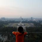 A girl looks on National Monument (Monas) as smog covers the capital city of Jakarta, Indonesia, July 4, 2019. REUTERS/Willy Kurniawan